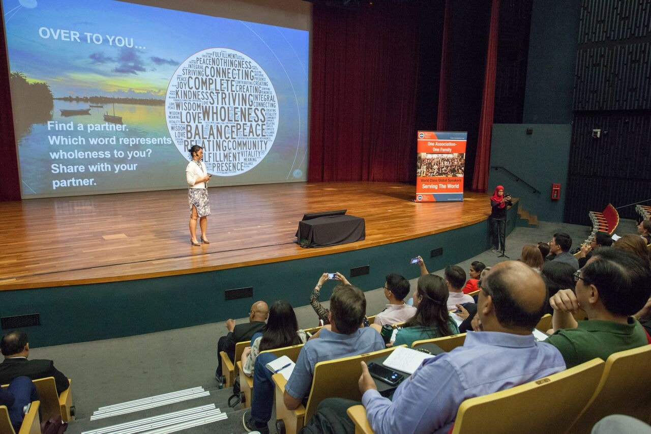 Wendy speaking to an auditorium audience